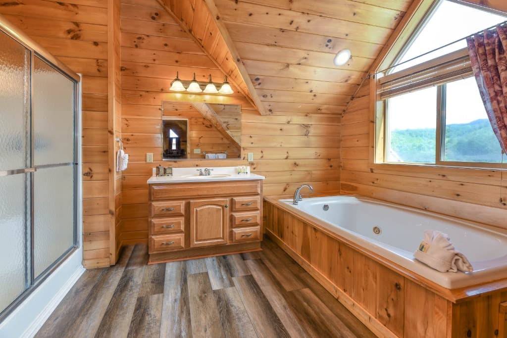 Rustic bathroom with jetted tub, wood paneling, and vanity at Moose Hollow Lodge in Sevierville